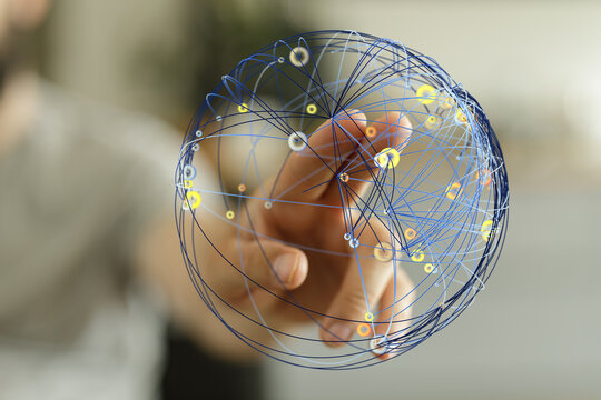 Close-up of a hand touching a network globe with lines representing connections. Conceptual image for global technology, communicatio