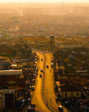 Aerial view of a golden sunset casting long shadows over the city streets and buildings, illuminating the iconic Mapo Hall, Ibadan, Oyo, Nigeria.