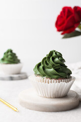 green frosting on cupcakes with a white background, cupcakes in white liners with tall buttercream swirl, green buttercream frosted cupcakes on a white background