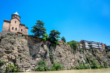 Metekhi Church and historic buildings on a cliff overlooking the Kura River in the center of Tbilisi, Georgia