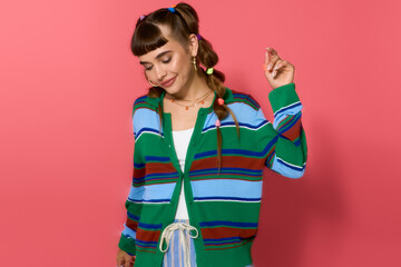 Stylish young woman poses in vibrant colors against a bright pink background