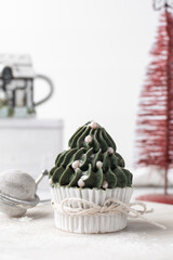 green frosting on cupcakes with a white background, christmas tree cupcakes in white liners with tall buttercream swirl, christmas green buttercream frosted cupcakes on a white background