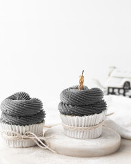 grey frosting on cupcakes with a white background, cupcakes in white liners with tall buttercream swirl, grey buttercream frosted cupcakes on a white background