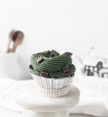 green frosting on cupcakes with a white background, cupcakes in white liners with tall buttercream swirl, green buttercream frosted cupcakes on a white background