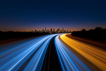 A vibrant night shot of a city skyline with streaks of blue and yellow light from moving vehicles on the highway.