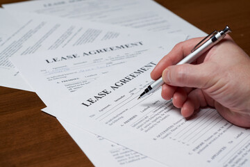 Lease Agreement. A person fills out a residential lease agreement. Selective focus. Document layout