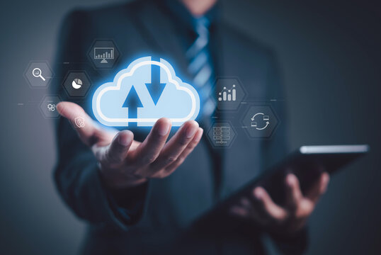 Businessman holding digital cloud computing icon with upload and download arrows, representing data storage, cloud service, online technology, and digital business transformation. - Powered by Adobe