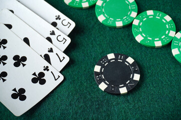 A game of cards and scattered chips on a poker table. A winning hand of two pairs. A successful casino game