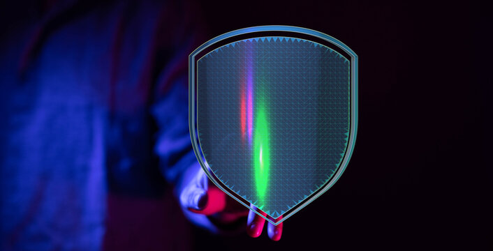 Abstract image of a person's hand holding a digital shield with glowing lines, symbolizing cybersecurity and data protection. Perfect