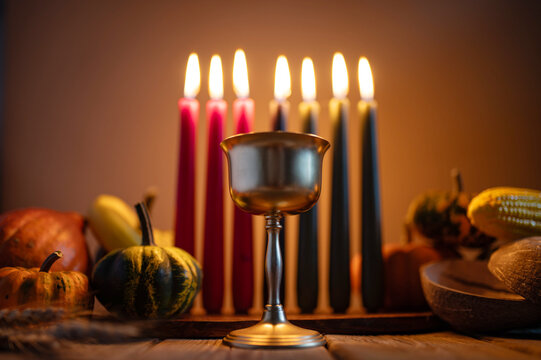 Kwanzaa, african holiday Kwanzaa with decoration of seven candles in red, black and green colors, vegetable harvest, corn. Greeting card banner. Happy Kwanzaa - Powered by Adobe