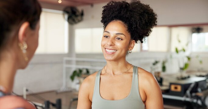 Women, personal trainer and talking to client in gym, conversation or listening to positive feedback. Happy, people and instructor with fitness tips, advice and discussion on break in health club - Powered by Adobe