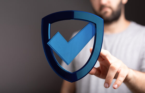 A man's hand interacts with a digital shield icon featuring a checkmark symbol, representing security and validation. Perfect for cyb