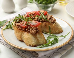 Delicious bruschettas with tuna, tomatoes and arugula on white table, closeup