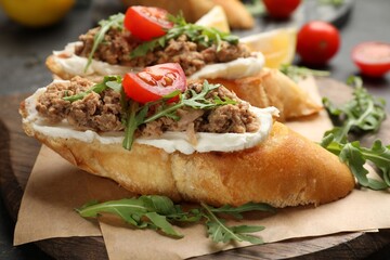 Delicious bruschettas with tuna, cream cheese and tomatoes on grey table, closeup