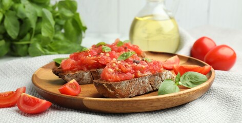 Tasty bruschettas with tomatoes and basil on table, closeup