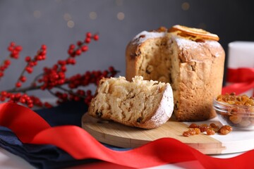 Christmas food. Delicious Panettone cake and festive decor on white table against background with blurred lights, closeup