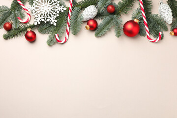 Naklejka premium Fir tree branches, candy canes and Christmas decor on light background, flat lay. Space for text