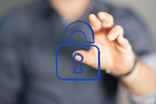 Abstract representation of cybersecurity and digital protection. A human hand interacts with a virtual blue padlock icon, symbolizing data priva - Powered by Adobe