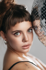 Young Blue-Eyed Woman Pressing Her Face Against a Disco Ball