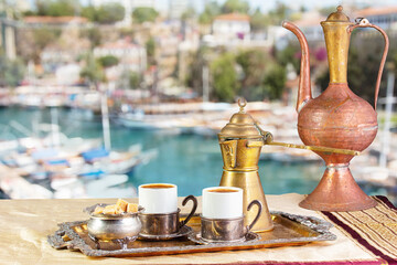 still life with eastern coffee set on table. Mediterranean Sea on a sunny summer day in the background.