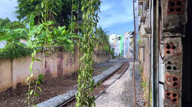 Nha Trang, Vietnam - 10.09.2025. A street with a train in Nha Trang, which runs between old residential buildings, almost at the very windows and doors. Railway tracks. Asia.4К