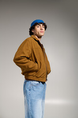 Stylish young man showcases modern fashion with confidence in a studio setting