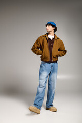 Stylish young man poses confidently in trendy attire against a neutral background