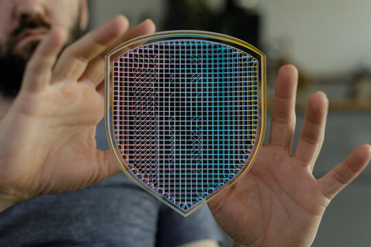 Abstract image of hands protecting a digital shield with a cyber security theme. Data protection, network security, and privacy are k