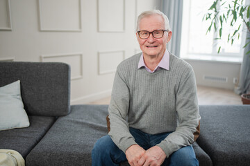 Fototapeta premium Portrait of confident stylish European middle aged senior man at home. Older mature 70s man smiling. Happy attractive senior grandfather looking camera close up face headshot portrait. Happy people