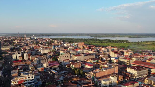Aerial footage of sprawling city of Iquitos, Peru. Urban landscape of houses and buildings meets the lush green Amazon rainforest
