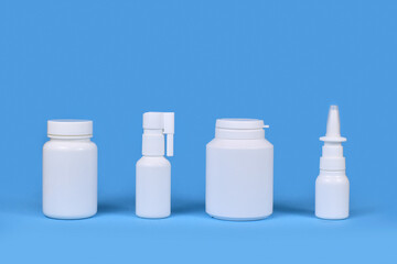 Medication for cold and flue. Nasal spray, throat spray, pills in a row on blue background