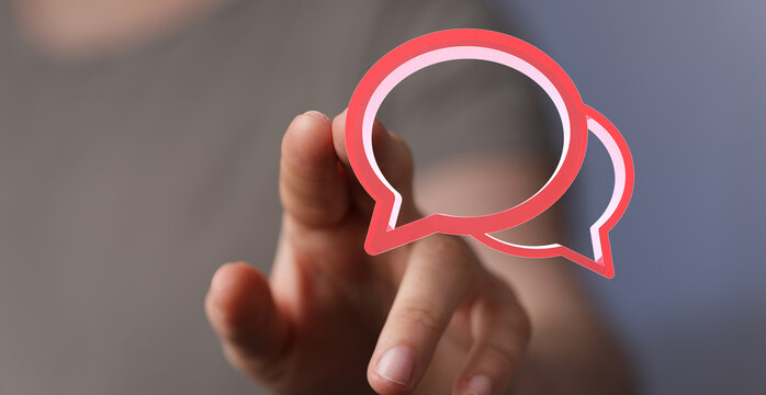 Hand touching a red speech bubble, symbolizing digital communication, online messaging, and discussion. Concept of connection and interaction.