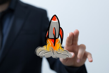 Conceptual image of a hand launching a digital rocket. Represents business startup, innovation, and...