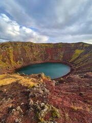 Kerið is a striking volcanic crater lake in South Iceland, known for its vivid red slopes, green moss, and turquoise water—one of the country’s most colorful geological wonders. © Aiste