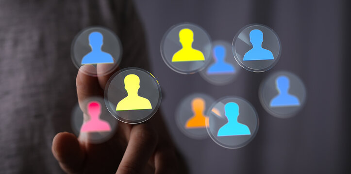 Conceptual image of a hand interacting with digital icons representing people, symbolizing communication and teamwork.