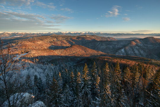 Aerial view of snow-dusted Lubietovsky Vepor mountain peaks kissed by the golden light of dawn, Lubietova, Banska Bystrica Region, Slovakia.