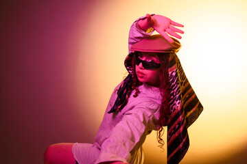 Fashionable woman posing in creative studio lighting