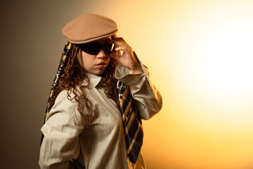 Young woman posing with beret, sunglasses, and style