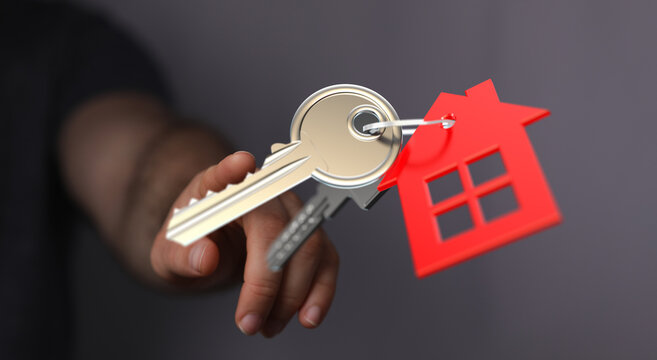 Hand holding keys with a red house charm, representing home, security, new beginning, ownership, real estate and property investment - Powered by Adobe