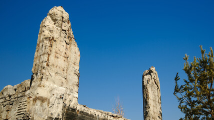 Ruins of building stone wall against clear blue sky