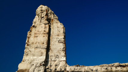 Ruins of building stone wall against clear blue sky