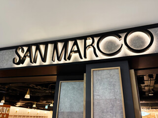 Fototapeta premium San Marco restaurant in Dublin Ireland interior with diners, modern lighting, and stylish signage