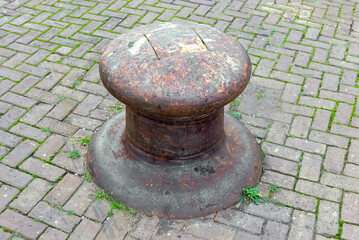 weathered bollard on the harbor quay