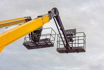 aerial platforms with work baskets stand out against a dark gray sky