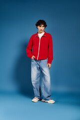 Fototapeta premium Stylish young man showcasing fashionable attire against a vibrant blue background
