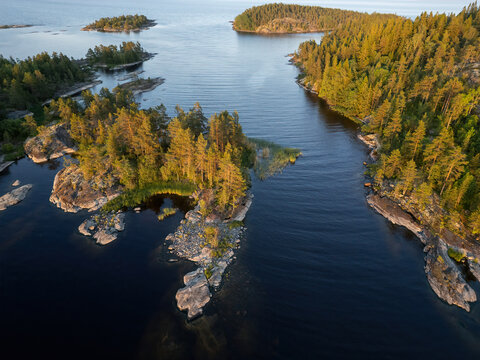 Aerial view of rocky islands crowned with emerald forests meet the deep blue waters of Lake Ladoga, a serene landscape of untouched beauty, Sortavala, Russia.