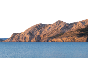 Rugged rocky coastal cliffs at sunset with serene blue sea. Isolated object
