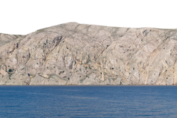 Rugged coastal cliff with clear blue water. Isolated object