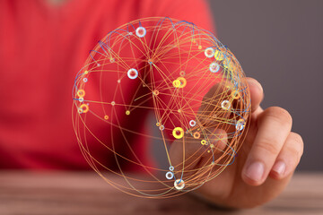 Abstract image depicting interconnected network. A hand holding a glowing sphere of connected lines...