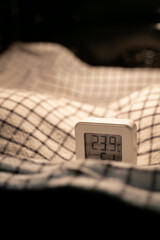 Digital thermometer measuring temperature inside an oven while bread dough rises